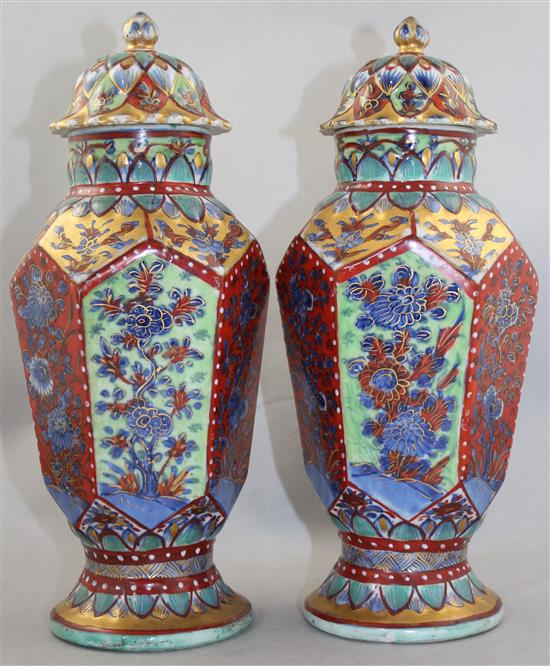 A pair of Chinese hexagonal baluster clobbered vases and covers, 18th century and later, 31.5cm